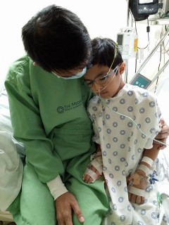 Gabgab being comforted by his dad before the colostomy procedure.